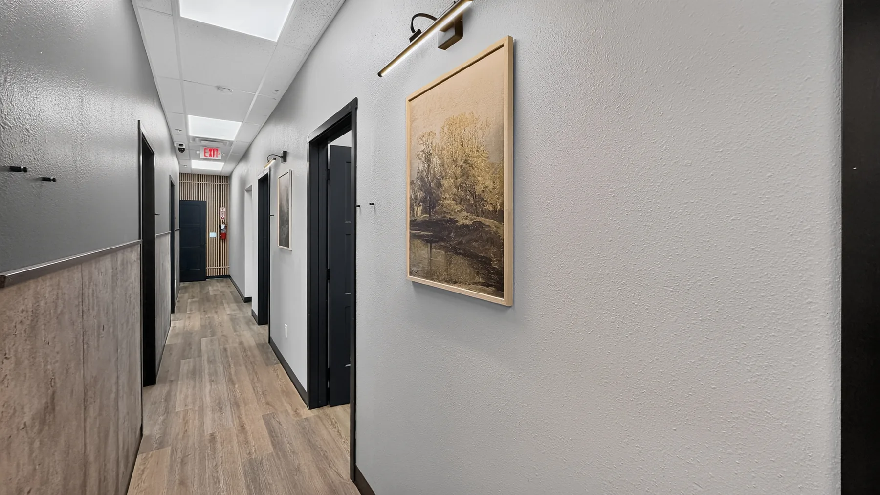 Hallway lined with individual black doors to private suites at The Beauty Spot