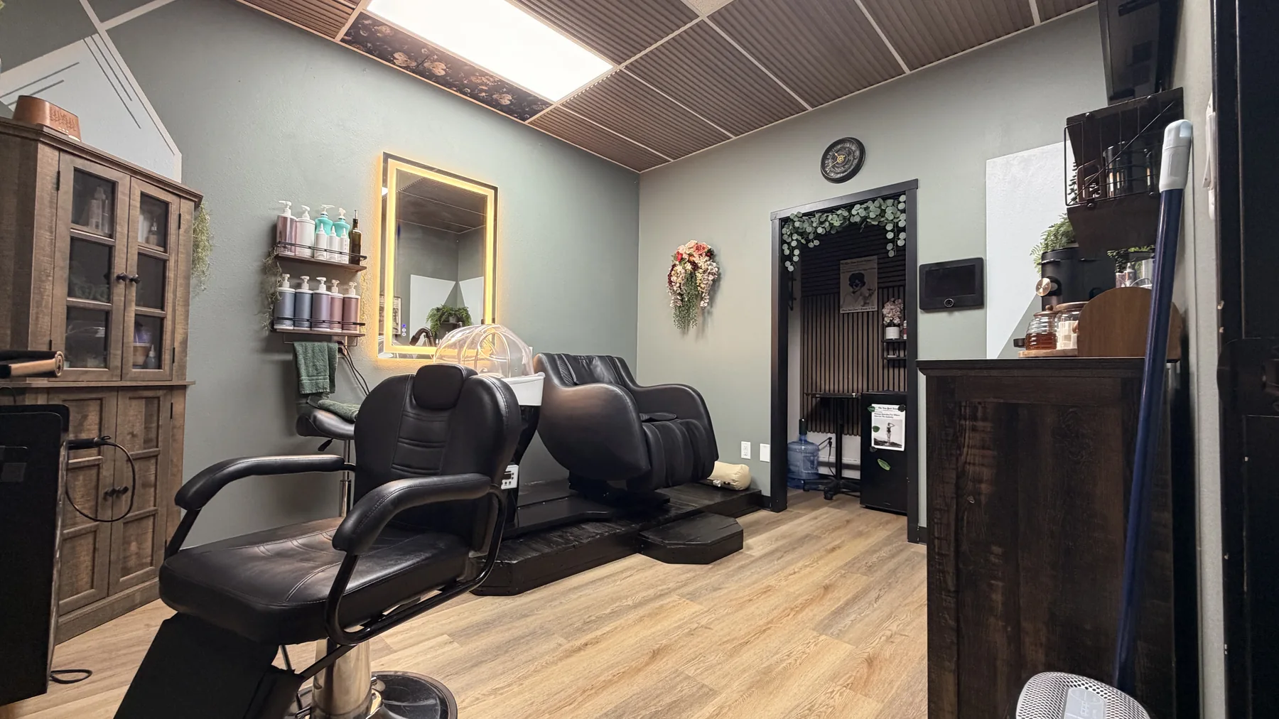 Customized suite with a warm wood ceiling, styling chair, wash chair, cabinetry, and product display
